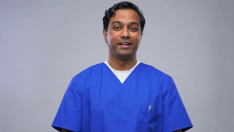 Indian-Doctor-or-Male-Nurse-Having-Video-Call.healthcare,-medicine-and-communication-concept-indian-doctor-or-male-nurse-in-blue-uniform-having-video-conference-over-grey-background